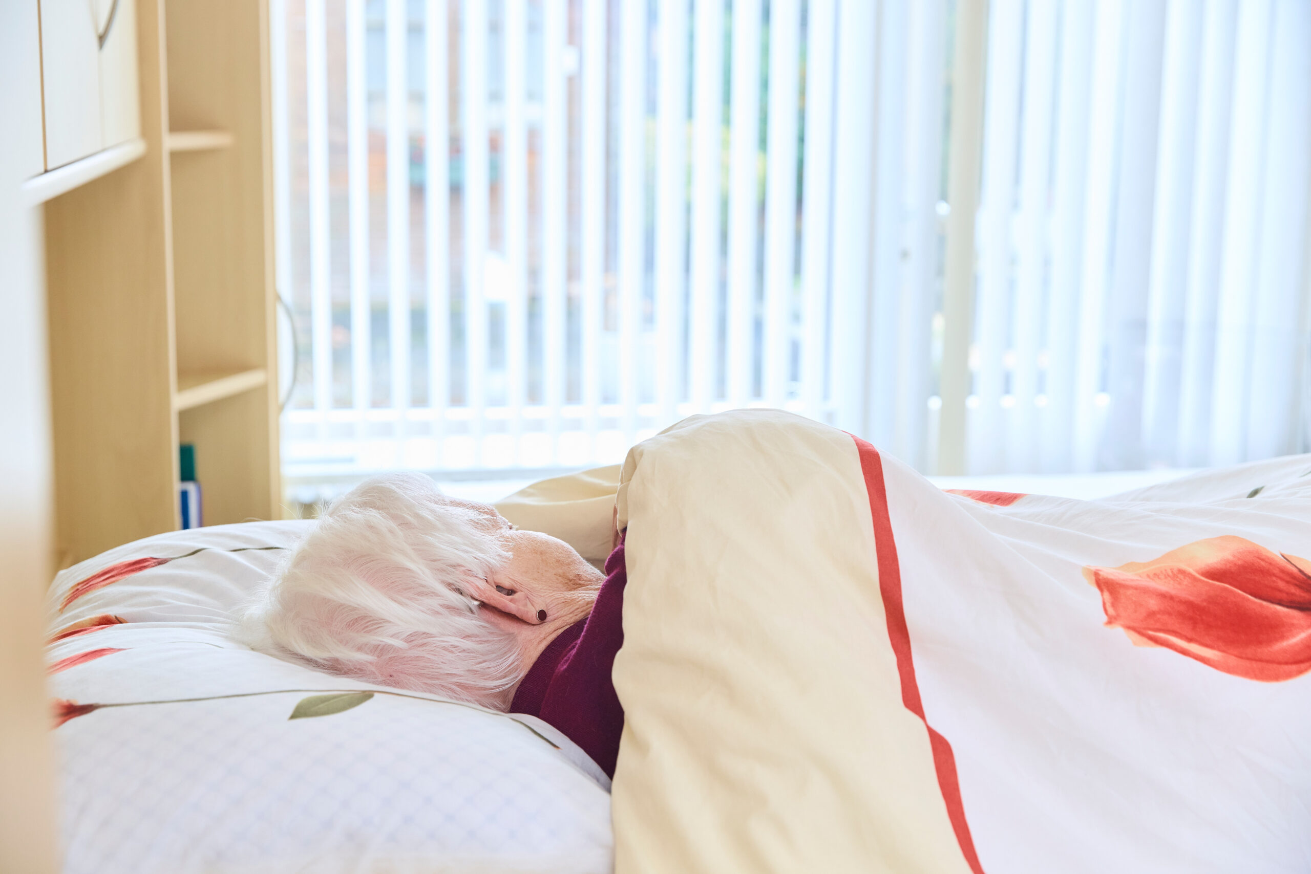 oudere cliënte in bed in wijk