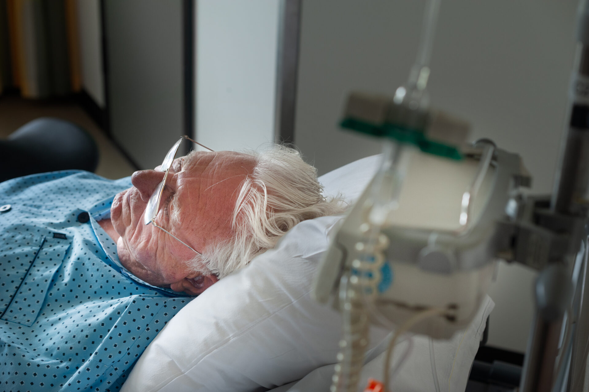 Man ligt in ziekenhuisbed.