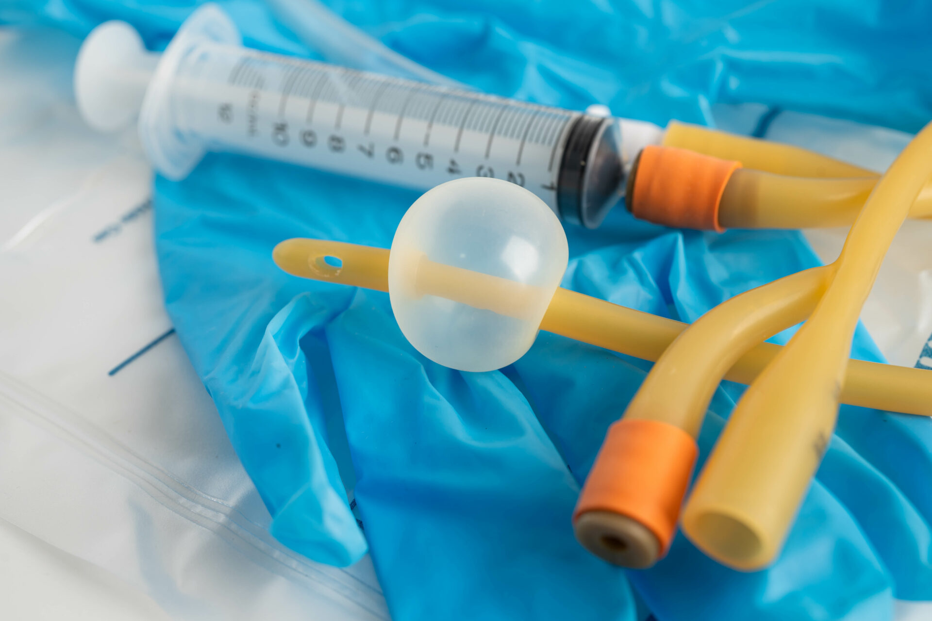 Transurethrale blaaskatheter met ballon en spuit, op niet-steriele handschoenen