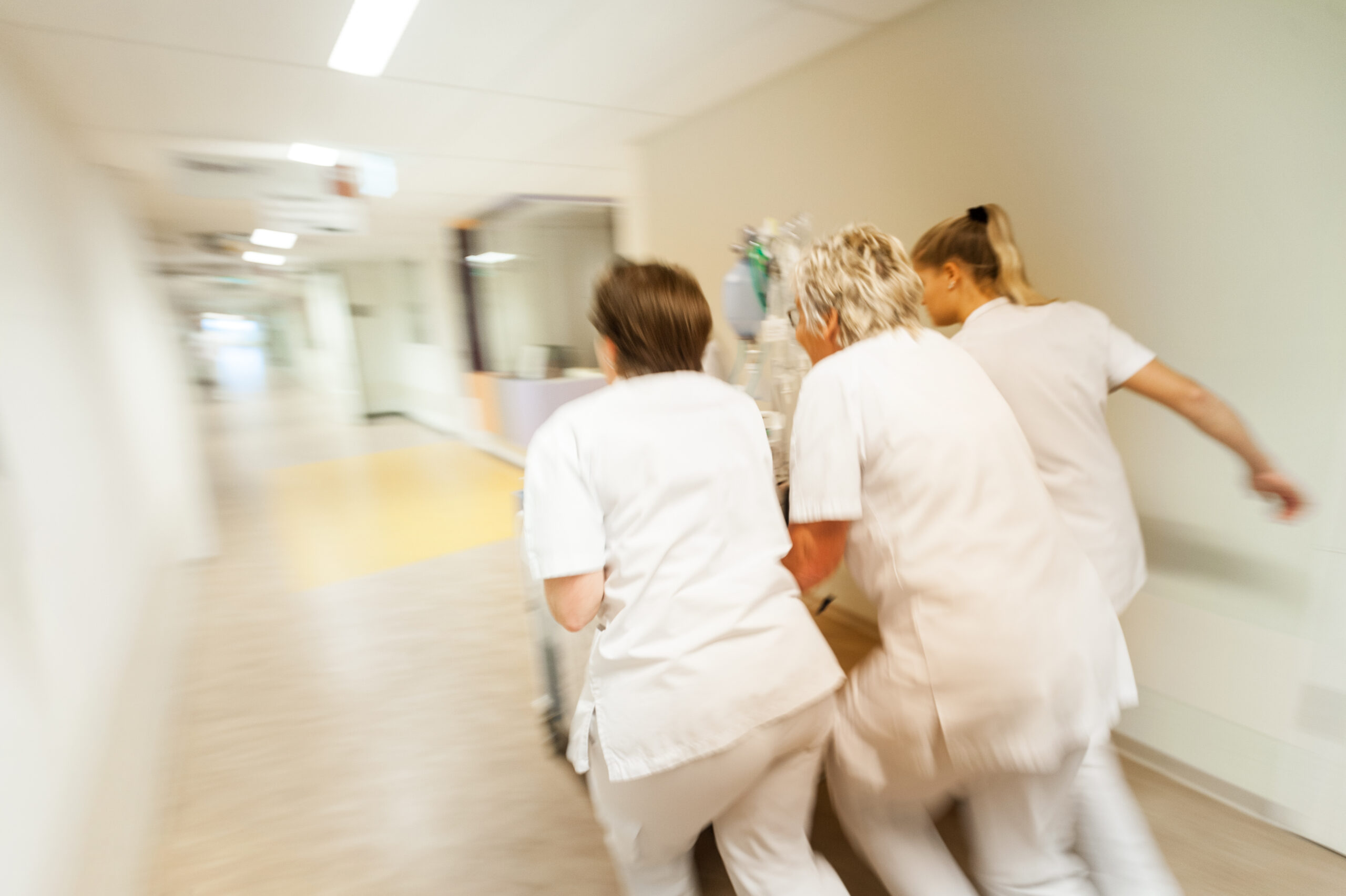 Verpleegkundigen rennen door de gang met crashcar