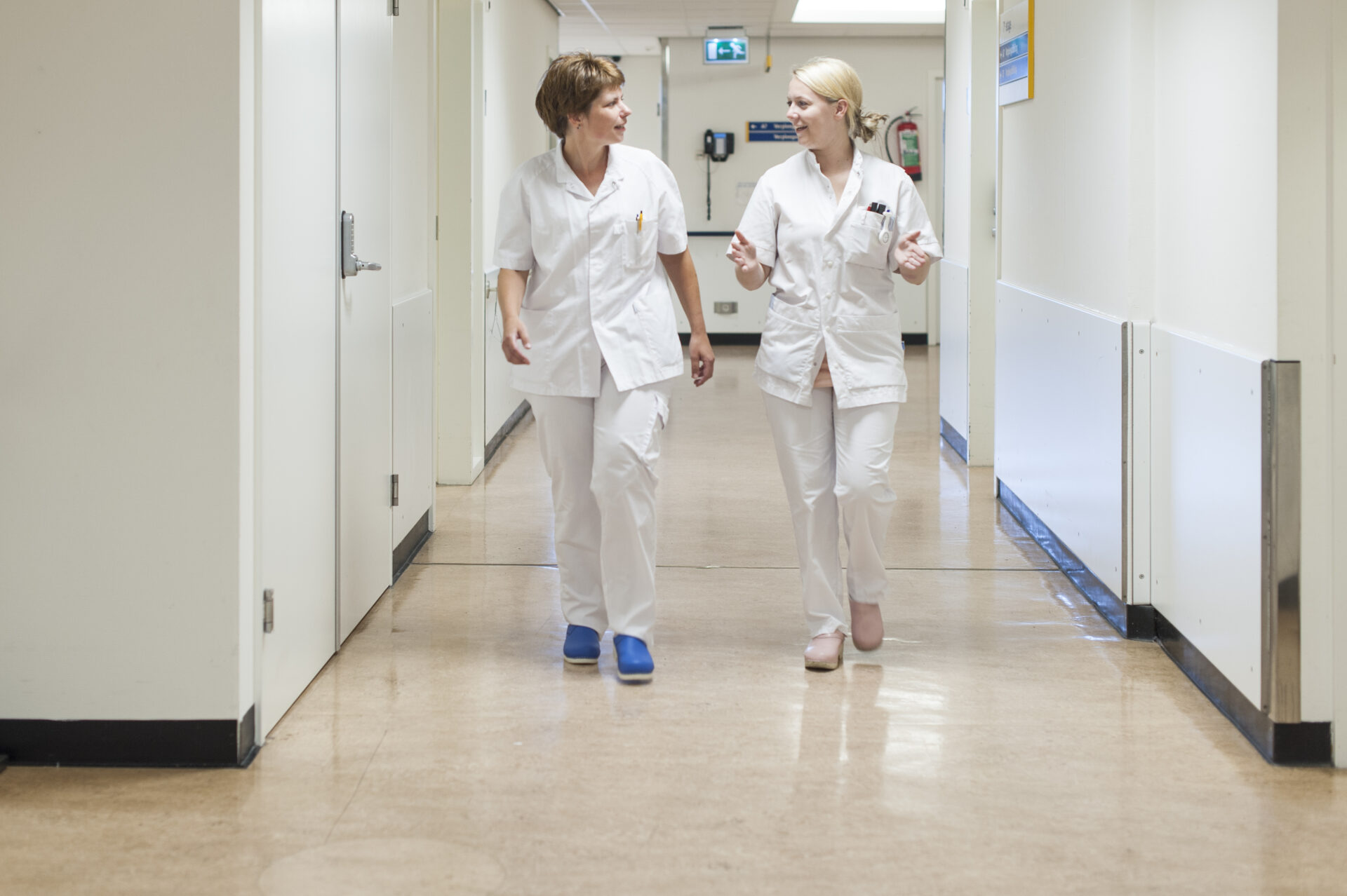 Verpleegkundigen lopen door een gang.