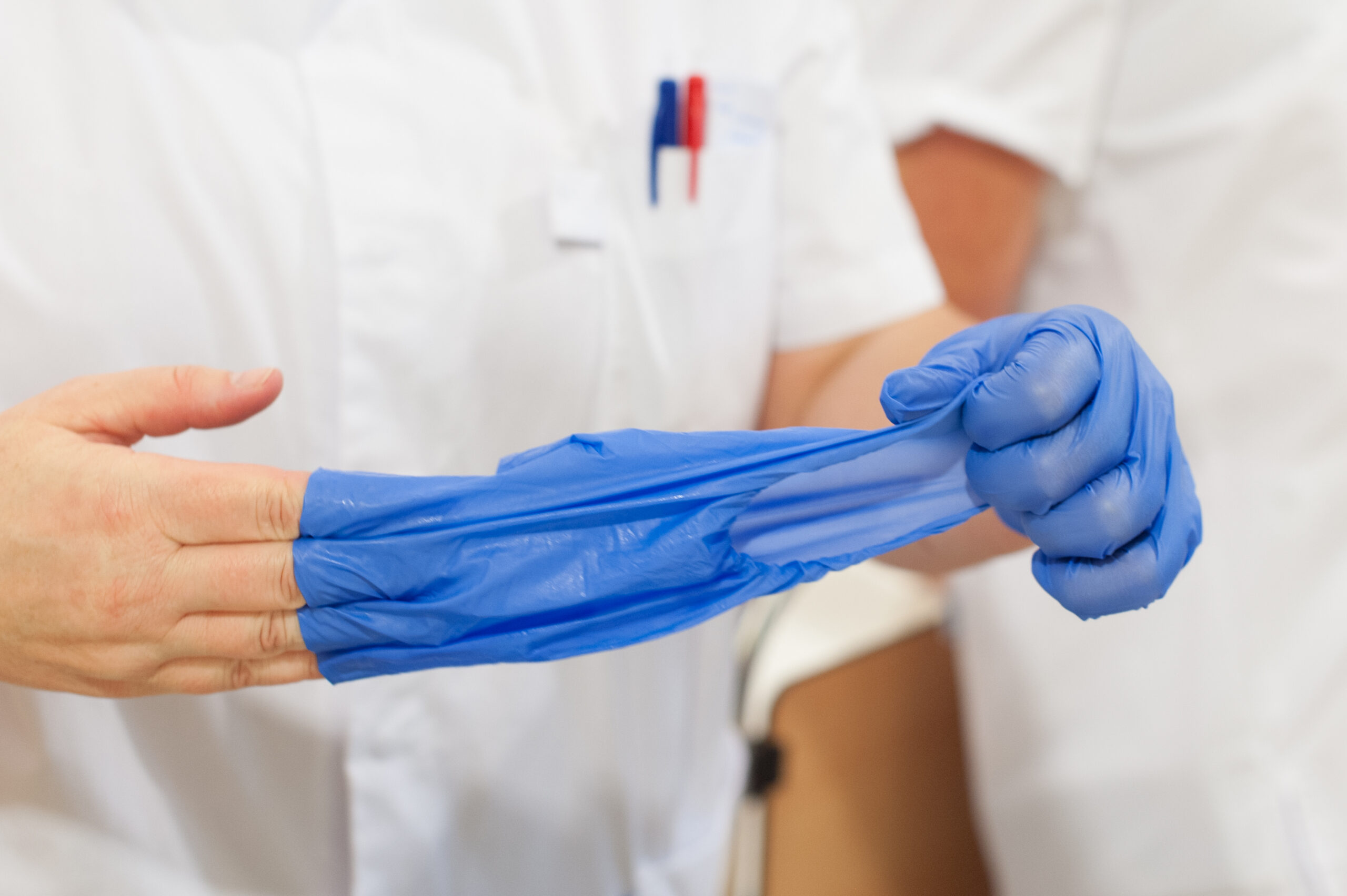 Verpleegkundige trekt handschoenen uit
