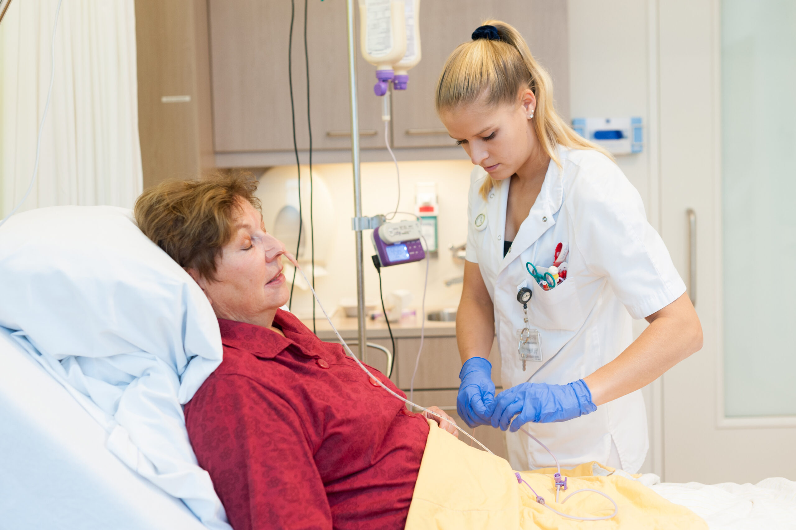 Verpleegkundige inspecteert neusmaagsonde bij patiënt