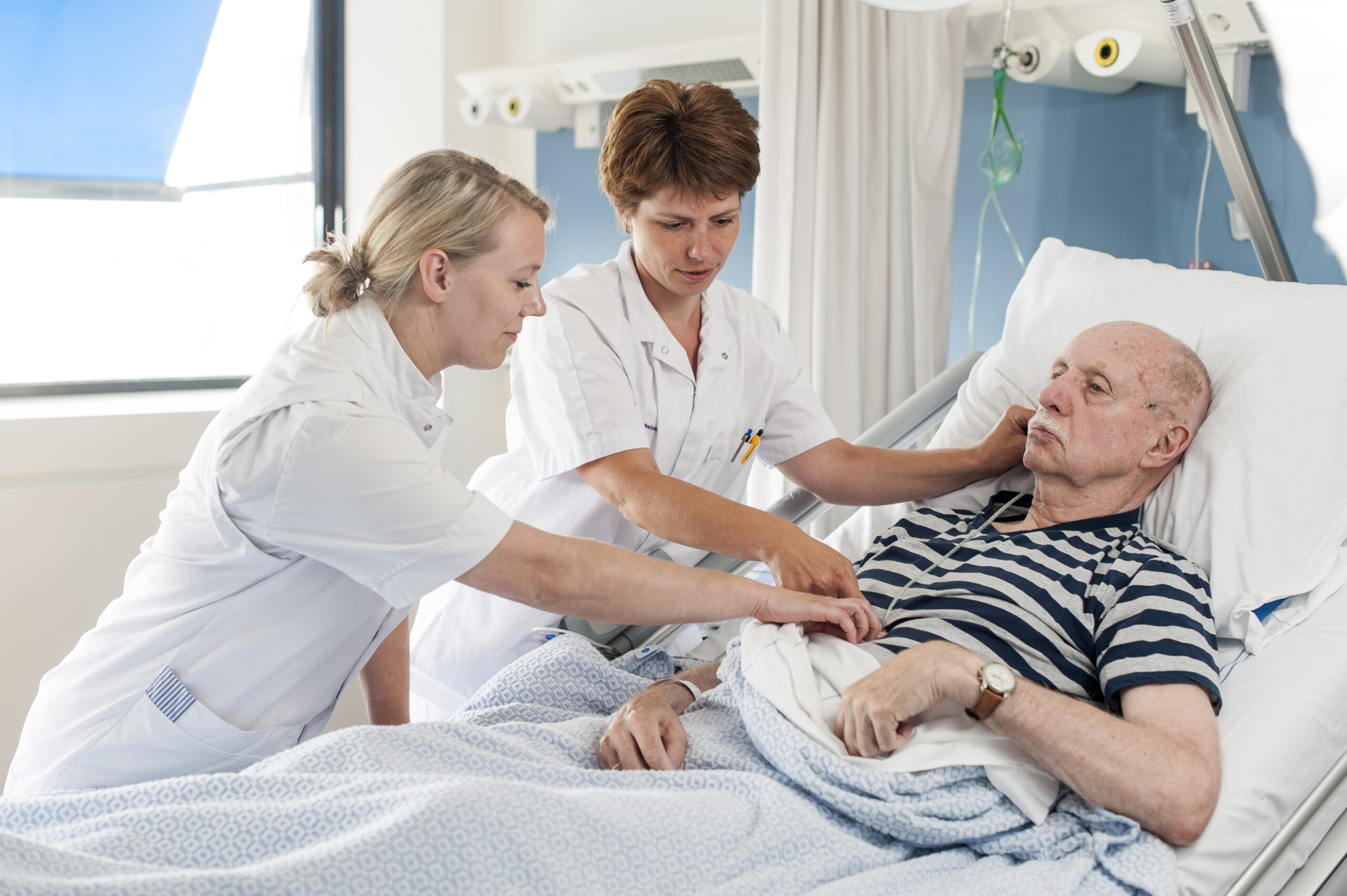 Twee verpleegkundigen bepalen de lengte van een maagsonde aan bij een oudere patiënt.
