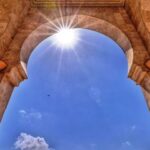 Marokkaanse poort tegen blauwe lucht met de zon