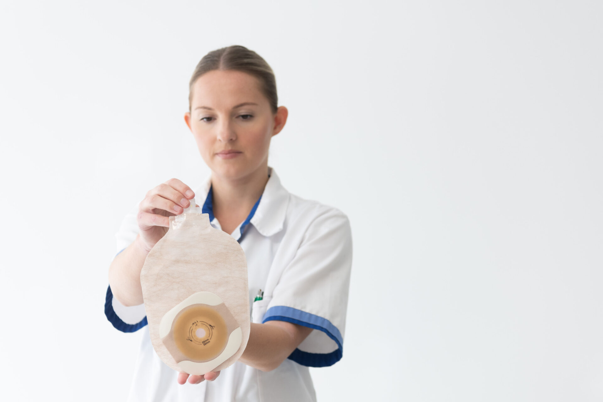 verpleegkundige houdt stomazak vast