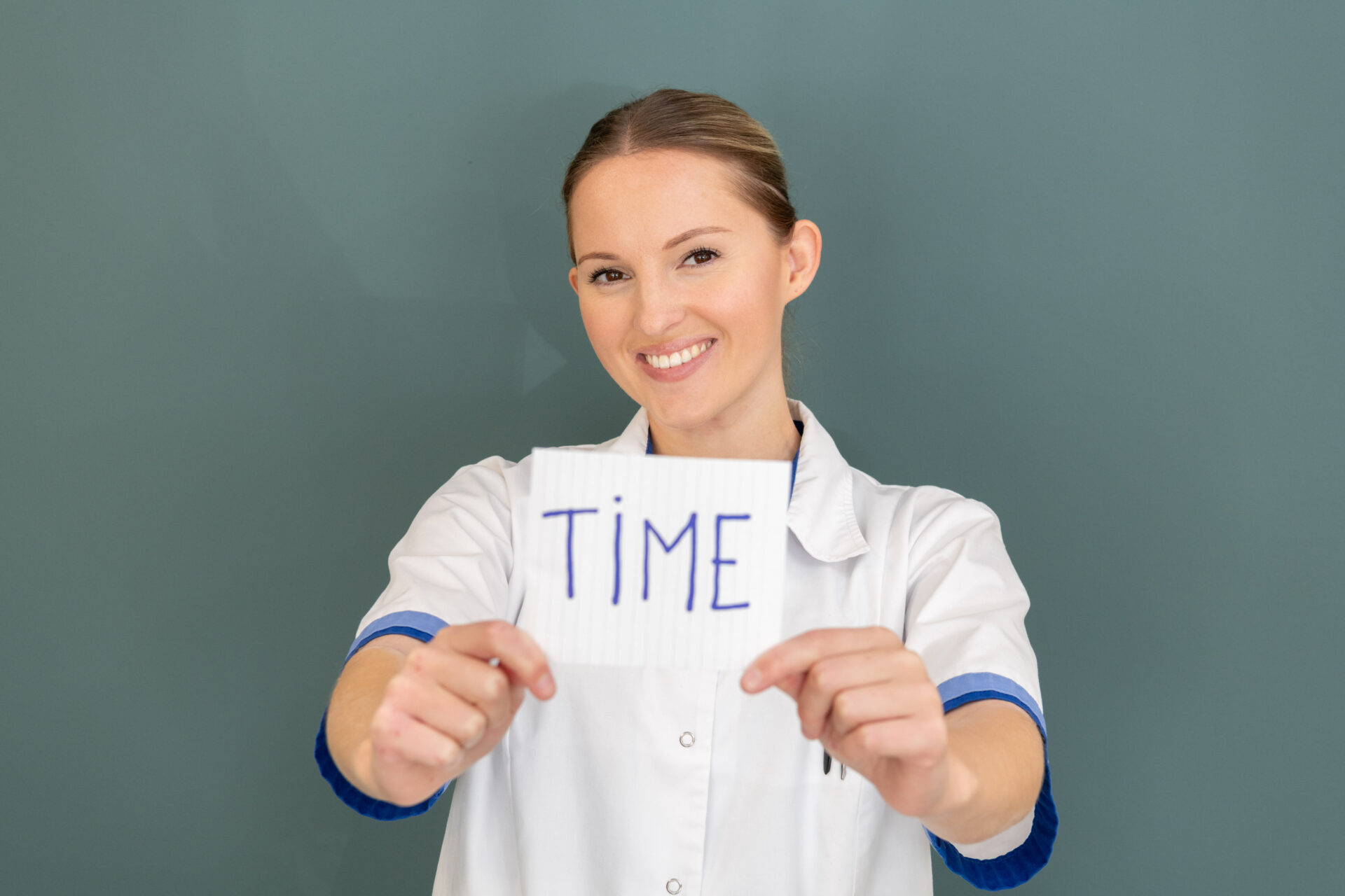 Verpleegkundige houdt papier vast met de letters TIME erop