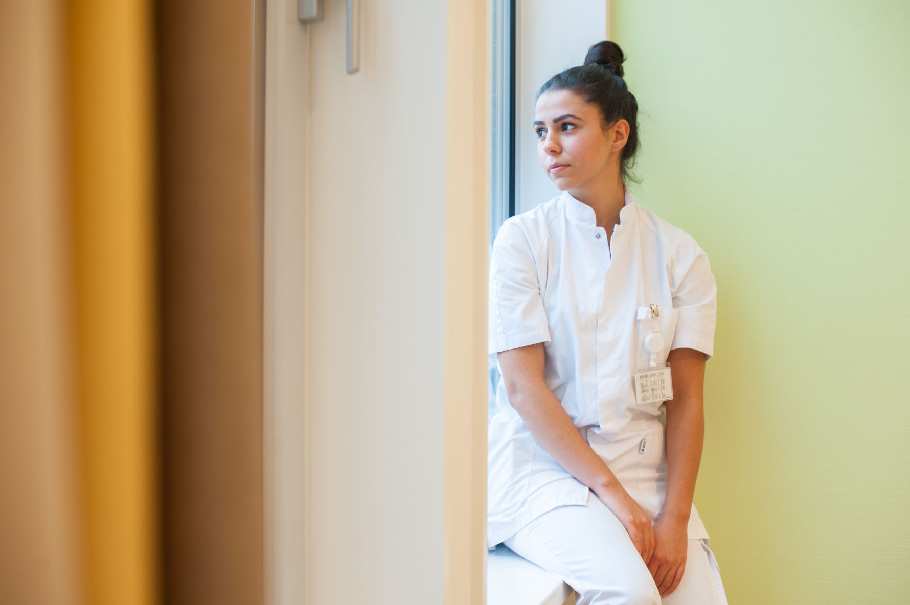 Verpleegkundige kijkt uit het raam