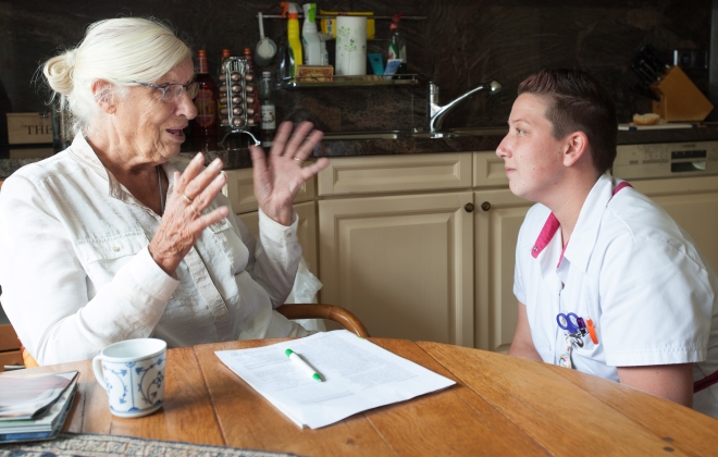 Een cliënt vertelt haar verhaal met gebaren, de verpleegkundige luistert aandachtig.